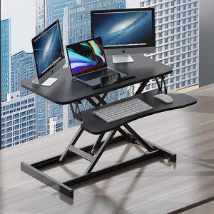 Höhenverstellbarer, schwarzer Schreibtischaufsatz in einem Anwendungsbeispiel mit zwei Bildschirmen, einem Laptop, einer Tastatur und einer Maus