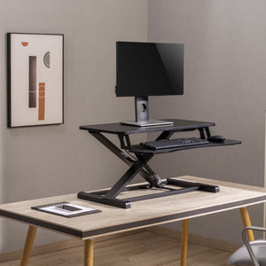 Höhenverstellbarer, schwarzer Schreibtischaufsatz in einem Anwendungsbeispiel mit einem Monitor, einer Tastatur und einer Maus